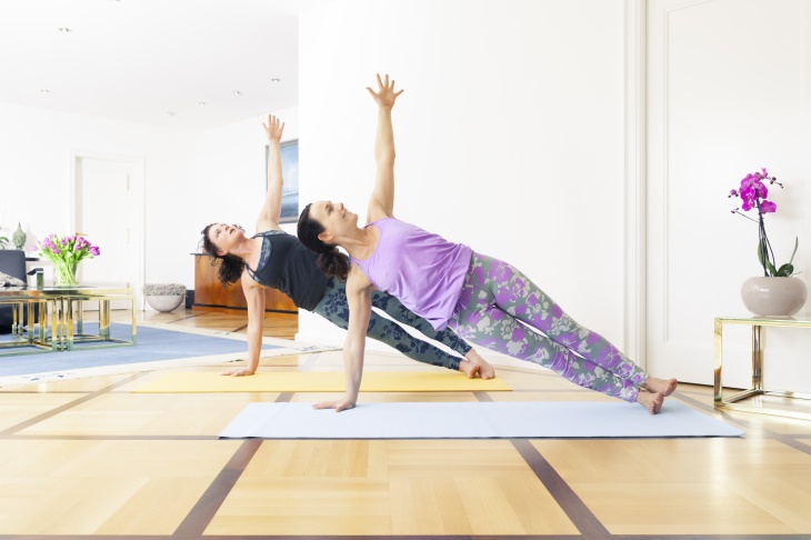 Two women doing yoga at home